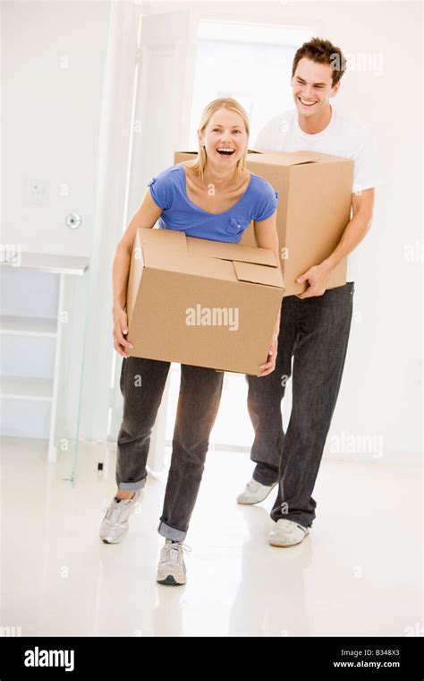 Couple With Boxes Moving Into New Home Smiling Stock Photo Alamy