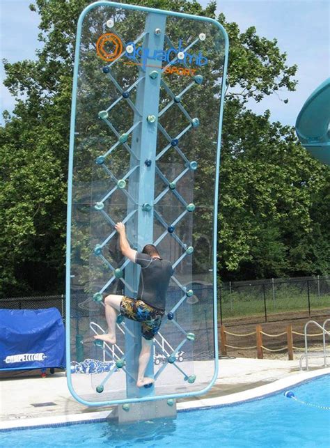 A Man Climbing Up The Side Of A Tall Metal Structure Next To A Swimming