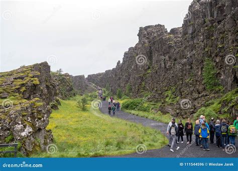Tourists Walk Through The Almannagja Fault Line In The Mid Atlantic