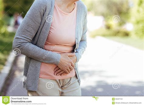 Upset Old Woman Having Sudden Pain In The Stomach Outdoors Stock Image