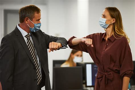 Man And Woman Touching Elbows And Avoiding Handshakes Stock Photo