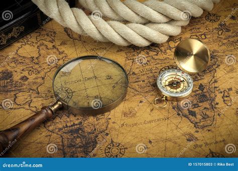 Vintage Compass And Magnifying Glass Lies On An Ancient World Map