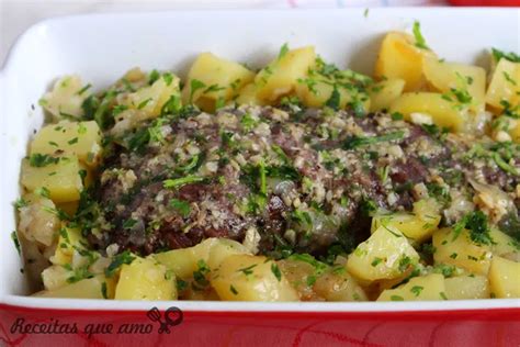 A White Dish Filled With Potatoes And Meat