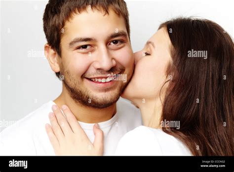 Happy Girl Kissing Her Boyfriend While He Looking At Camera Stock Photo