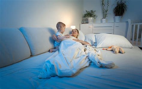 Baby Trying To Wake Tired Mother Sleeping In Bed Stock Photo Image Of