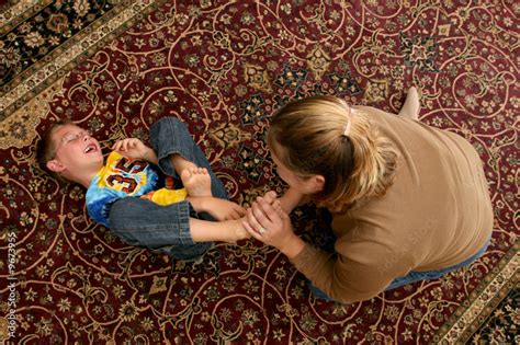 Mother Tickling Her Son S Bare Feet On The Floor Stock Photo Adobe Stock