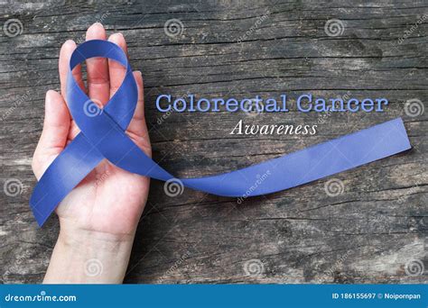 Colorectal Or Colon Cancer Awareness Dark Blue Ribbon On Helping Hand