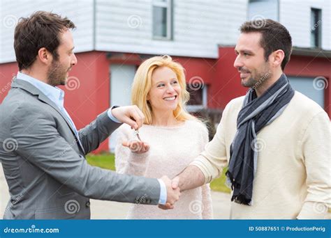 Real Estate Agent Delivers Keys To Young Atractive Couple Stock Image Image Of Attractive