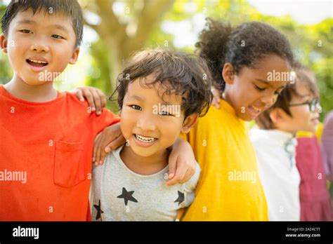 Multi Ethnic Group Of School Children Laughing And Embracing Stock