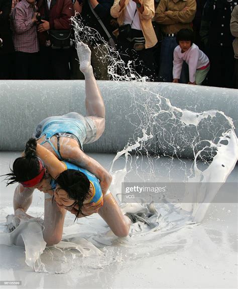 Two Chinese Women Wrestle In A Mud Pool During An International