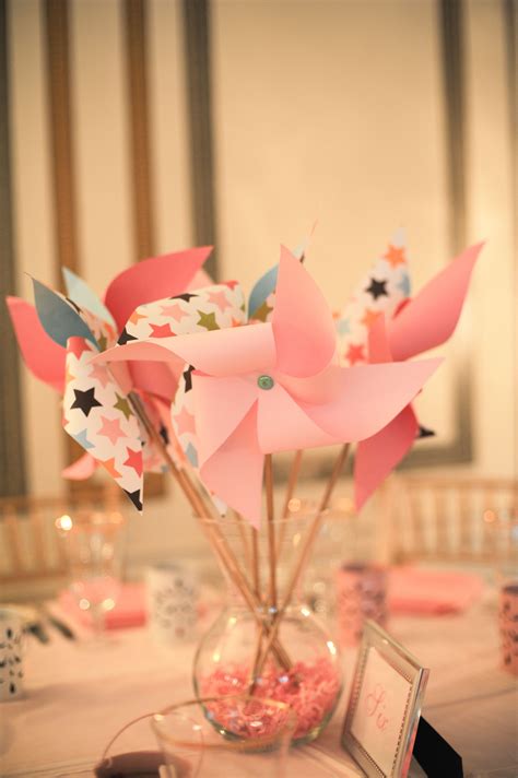 A Vase Filled With Pink And Blue Pinwheels Sitting On Top Of A Table