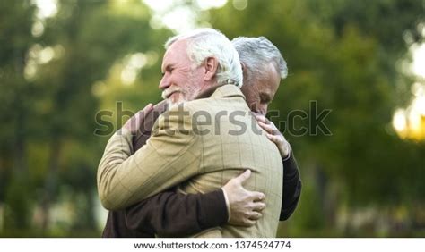 mature men hugging happy to see each other old friends meeting greeting