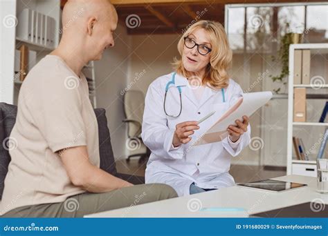 Mature Female Doctor Talking To Patient In Clinic Stock Image Image