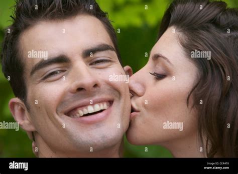 Profile Of Female On Right Brunette Hair Kissing Cheek Of Male On Left