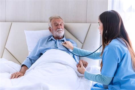 Caregiver Nurse Using Stethoscope Checking To Senior Patient Nurse