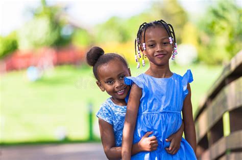 Outdoor Portrait Of A Cute Young Black Sisters African