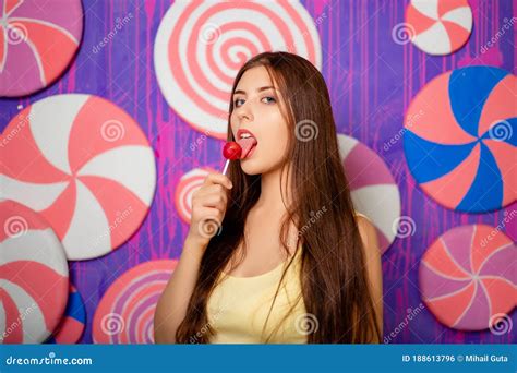 Portrait Of An Attractive Woman With A Lollipop In Her Hands On A