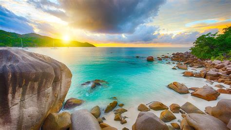 Stone Rocks On Beach Sand Landscape View Of Greenery Mountains Ocean Under Black Blue Clouds Sky