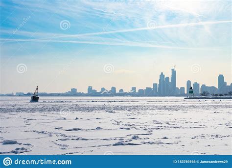A Buoy In A Frozen Lake Michigan In Chicago With The Skyline After A