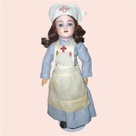 A Doll With Brown Hair And Blue Eyes Wearing A White Hat Dress And Apron