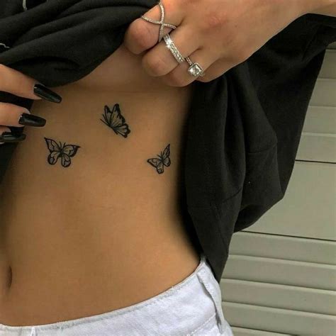 A Woman With Butterfly Tattoos On Her Stomach