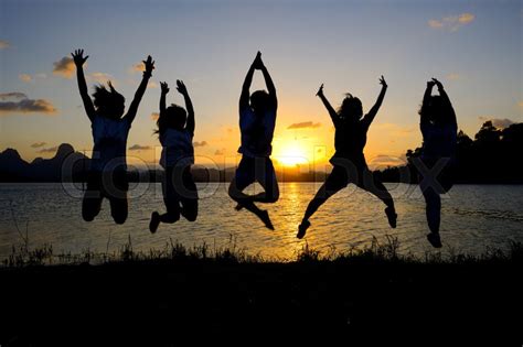 Silhouette Of Friends Jumping In Sunset Stock Image Colourbox