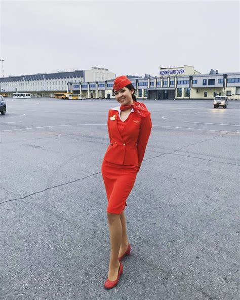 A Woman In An Air Hostess Uniform Standing On The Tarmac With Her Hand
