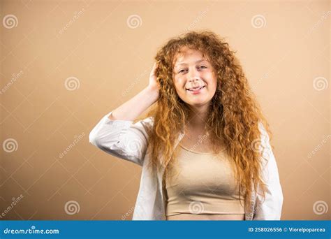 Happy Redhead Young Woman With Long And Wavy Hair Keeping Her Hand On