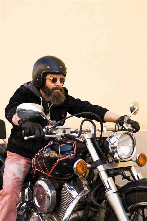 Portrait Of Bearded Biker Wearing Helmet And Sunglasses Sitting On His