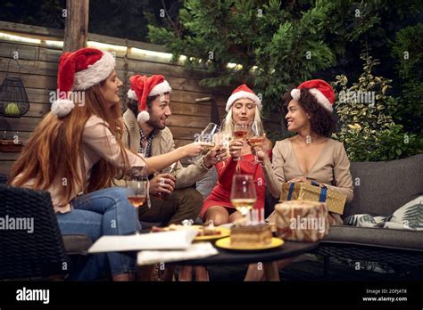 Drunk Young Adults Celebrating With Santa Clause Hats Toasting