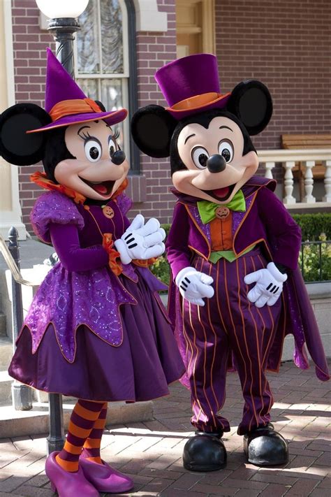 Two Mickey And Minnie Mouse Characters Standing Next To Each Other