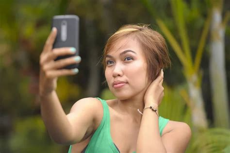 Young Sweet And Pretty Asian Woman Holding Mobile Phone Taking Selfie