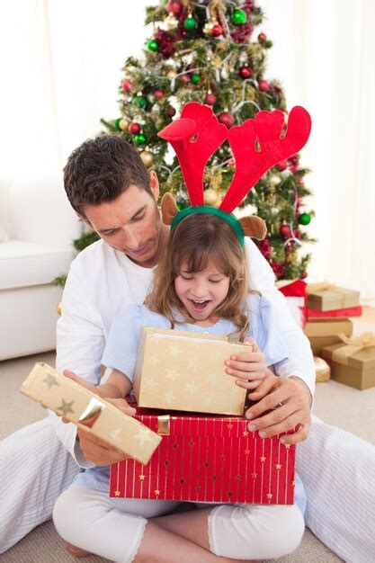 Feliz Padre Y Su Hija Abriendo Regalos De Navidad Foto Premium
