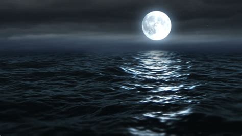 Full Moon In The Darkness Of The Night Sky Glowing Above The Ocean