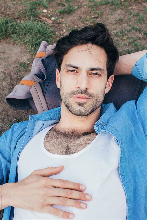 Headshot Of Handsome Caucasian Man Lying In Park With Head On Backpack