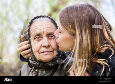 Picture Of A Beautiful Young Woman Kissing Her Sick Grandmother Stock