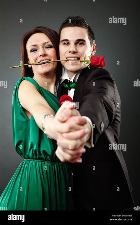 Beautiful Young Couple Dancing Tango And Holding A Rose In Their Stock