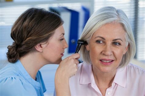 Premium Photo Doctor Examining Patients Ear With Otoscope
