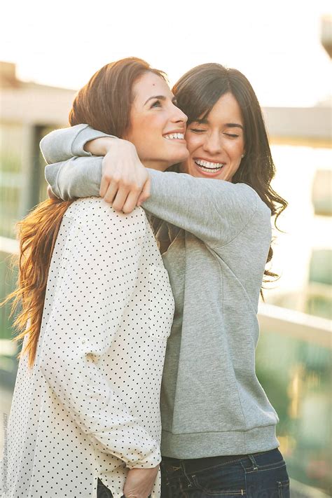 Happy Young Girlfriends Hugging Together On The City Del Colaborador