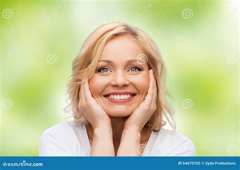 Uśmiechnięta Kobieta Dotyka Jej Twarz W Białej Koszulce Zdjęcie Stock