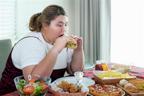 Asian Fat Girl Hungry And Eat A Junk Food On The Table Photograph By Anek Suwannaphoom