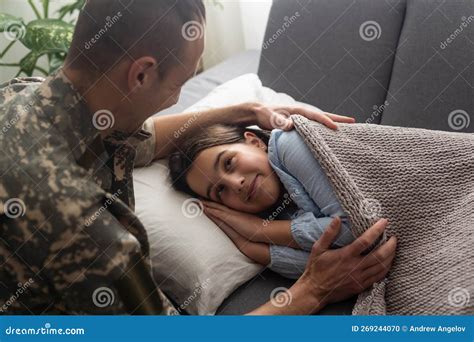 Soldado Besando A Su Hija Mientras Duerme En Una Cama En Casa Foto De