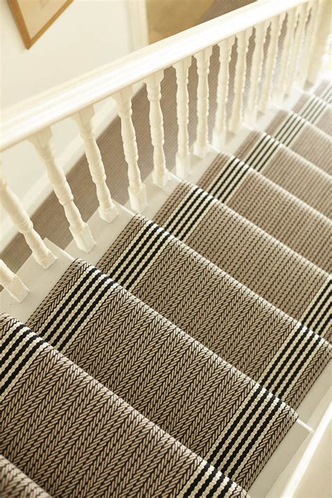 The Stairs Are Lined With Beige And Black Striped Carpet