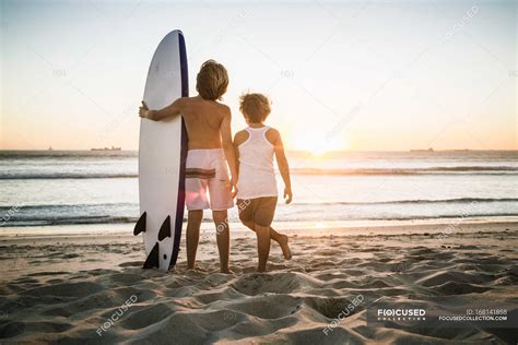 Deux Jeunes Gar Ons Debout Sur La Plage Avec Planche De Surf