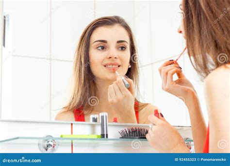 Smiling Beautiful Girl Paints Her Lips In Front Of The Mirror Stock Image Image Of Beauty