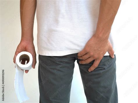 Man Has Diarrhea Holding His Bum On Bathroom Background And Hemorrhoid Closeup Photo Blurred