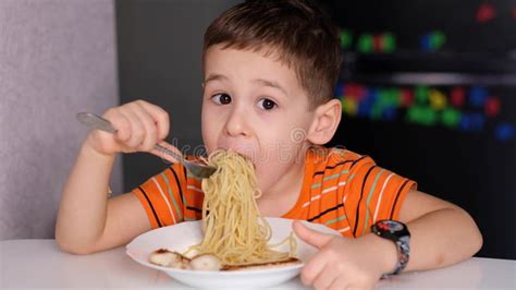 Funny Little Boy Eat Pasta In The Kitchen Table Stock Photo Image Of
