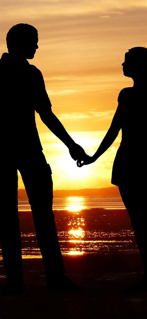 Couple Holding Hands In The Sunset Wallpaper