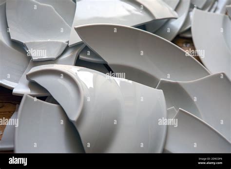 Close Up Of Pile Of Broken White Plates Shattered On Floor Stock Photo