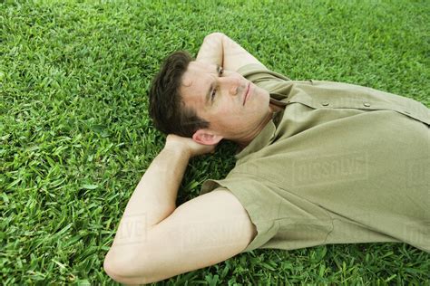 Man Lying On Grass Hands Behind Head Stock Photo Dissolve